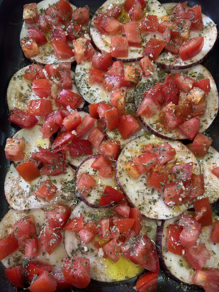 Melanzane a strati con pomodori, aglio, prezzemolo, origano e peperoncino