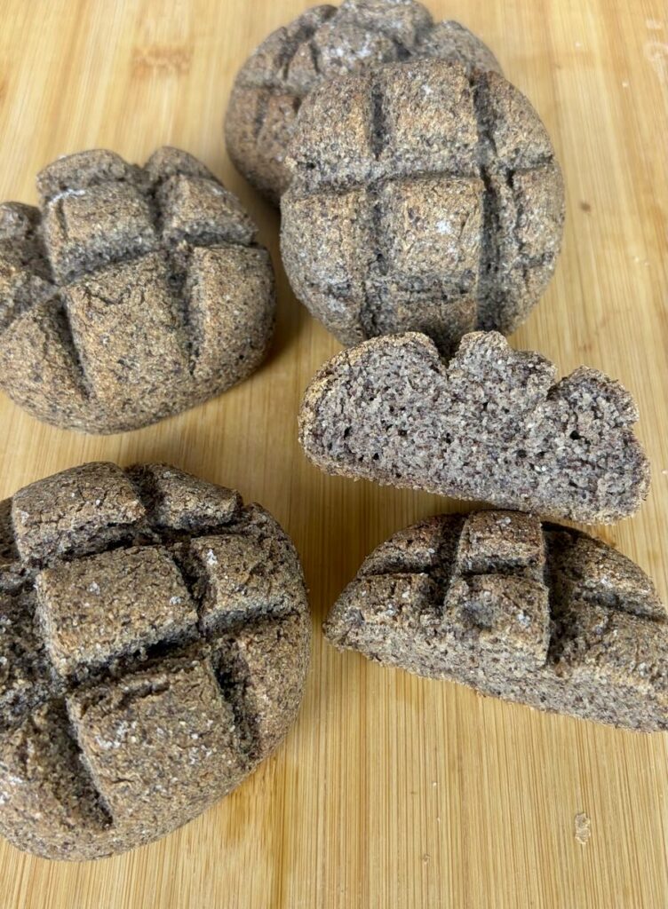 Panini al grano saraceno senza glutine fatti in casa, uno tagliato per mostrare la mollica