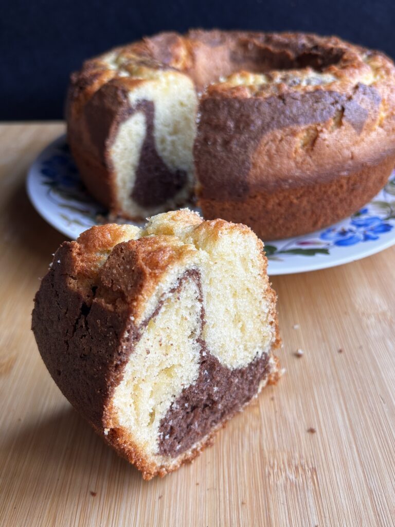 Ciambella al cacao soffice e variegata, con impasto alla vaniglia e al cacao, servita a fette su un piatto.