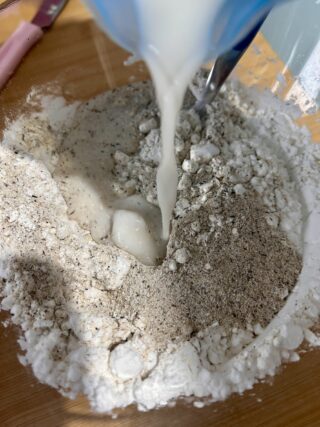 Miscela di farina di grano saraceno, fecola di patate e amido di mais con acqua versata al centro per preparare panini senza glutine.
