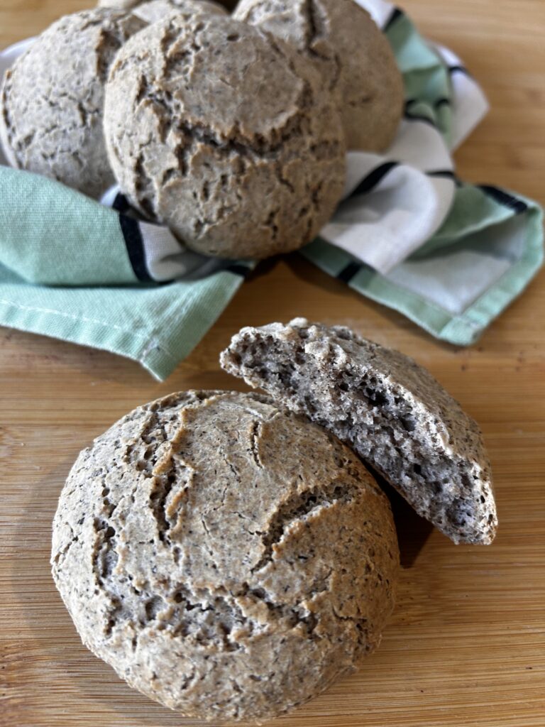 Panini al grano saraceno senza glutine, uno intero e uno tagliato a metà per mostrare la mollica interna.
