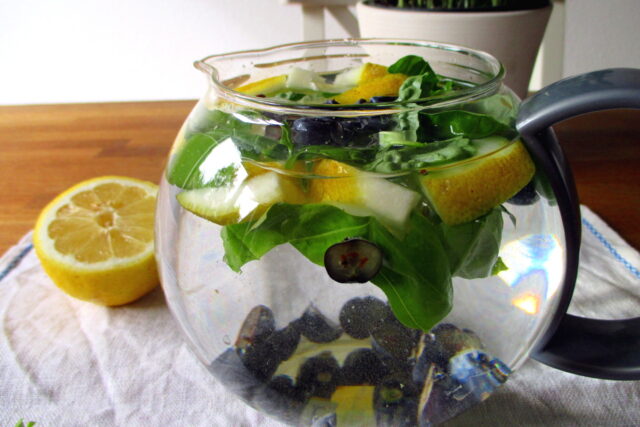 Brocca in vetro con acqua in infusione per la bevanda depurativa basilico e limone