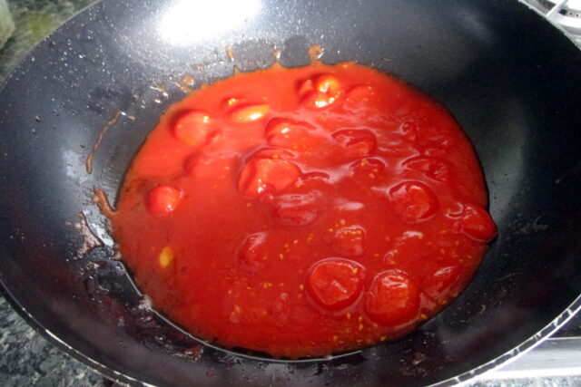 Pasta con friggitelli e pomodorini, pomodorini in cottura che si restringono