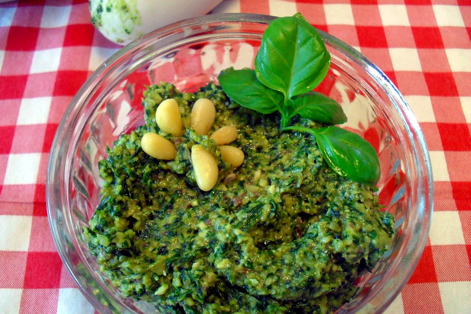 Pesto di basilico light in ciotola di vetro tonda su tovaglia a scacchi bianchi e rossi