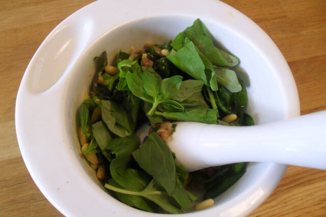 Preparazione pesto di basilico light: inserimento di altre foglie di basilico fresco con il pestello bianco