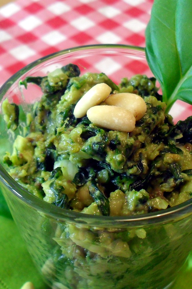 Pesto di basilico light nel bicchiere con pinoli e foglia di basilico fresco