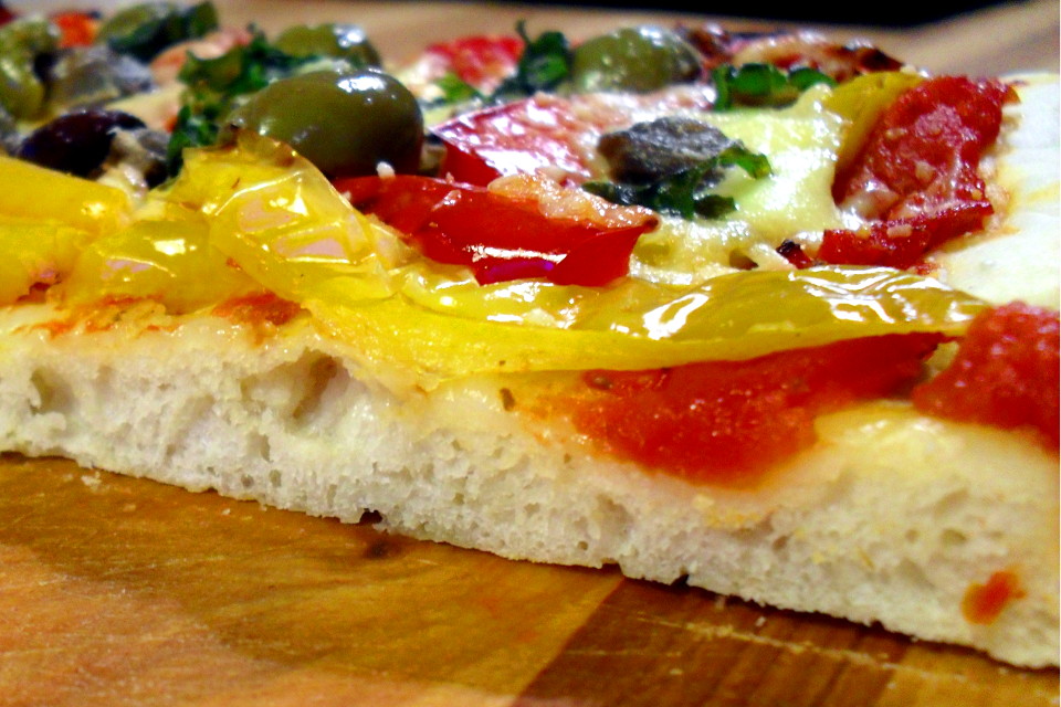 Preparazione pizza peperoni e olive light: dettaglio dell'impasto soffice in sezione dopo il taglio