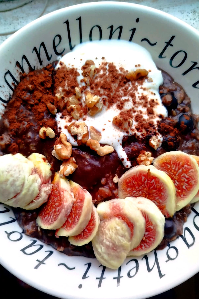 Porridge al cacao vegano con yogurt, noci, mirtilli e fichi freschi a fettine