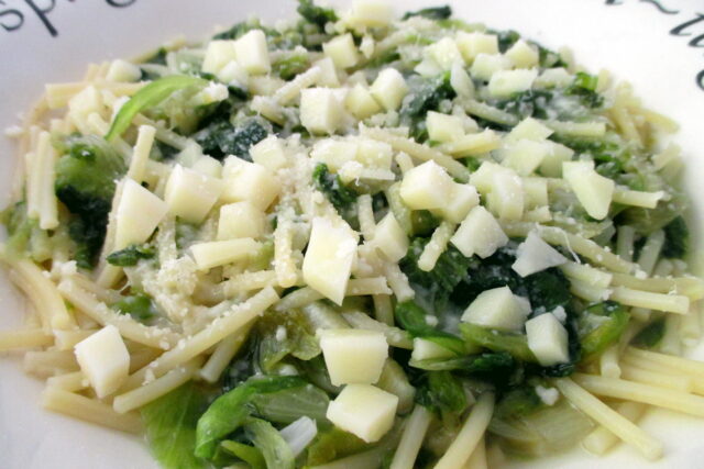 Primo piano della pasta con scarola, con spaghetti e foglie di scarola ben visibili