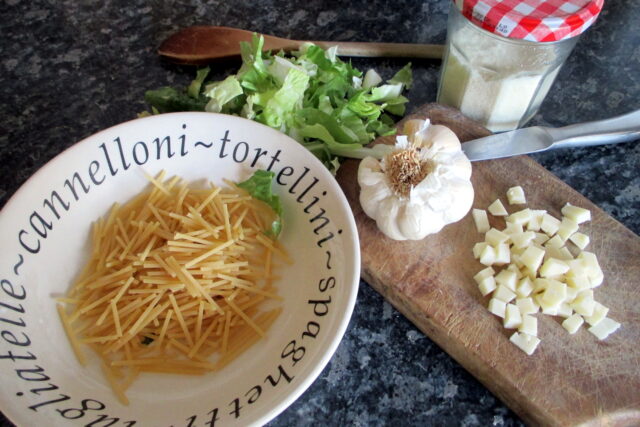 Ingredienti per la pasta e scarola: scarola, spaghetti, aglio, parmigiano e formaggio a dadini