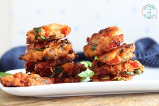 frittelle alla greca con pezzi di pomodoro cipolla basilico e farina fatte in padella