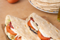 Piadina con verdure grigliate, salsiccia sarda, pomodori e mozzarella: ricetta facile e filante