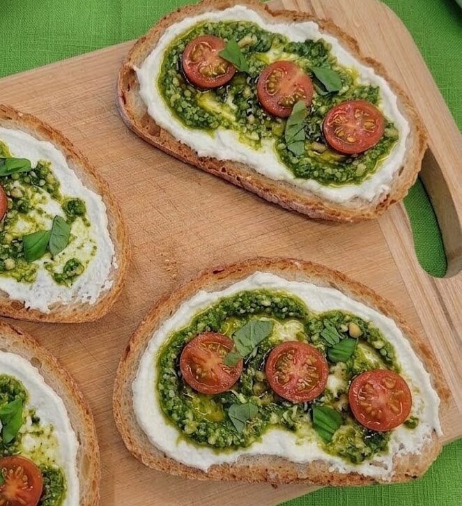 Bruschette sfiziose con formaggio spalmabile, pesto e pomodorini