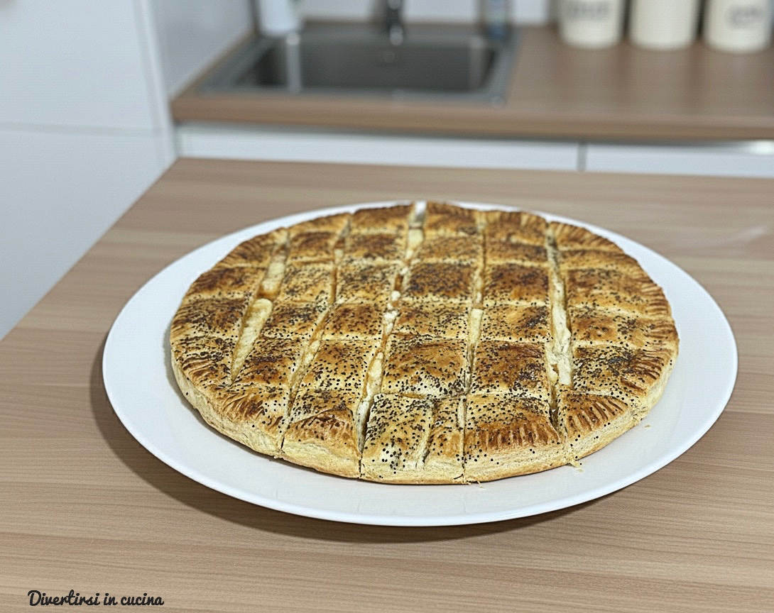 Quadrotti di sfoglia dorati farciti con prosciutto cotto e provola filante, decorati con semi di papavero