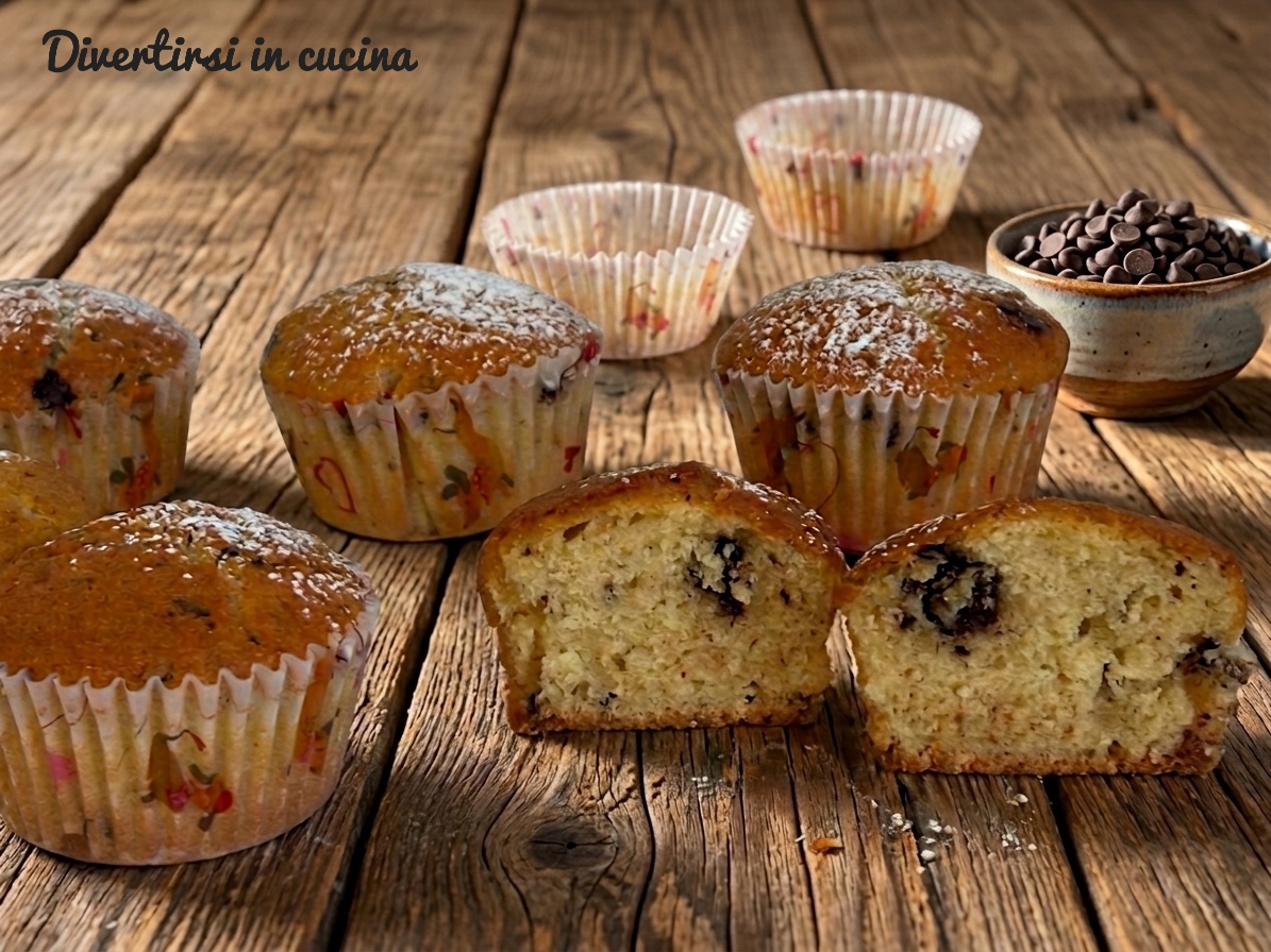 Muffin soffici allo yogurt spolverati di zucchero a velo con gocce di cioccolato su un piano di legno