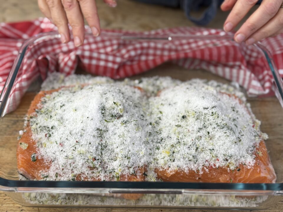 Mettere a marinare il salmone con sale, zucchero e trito di erbe