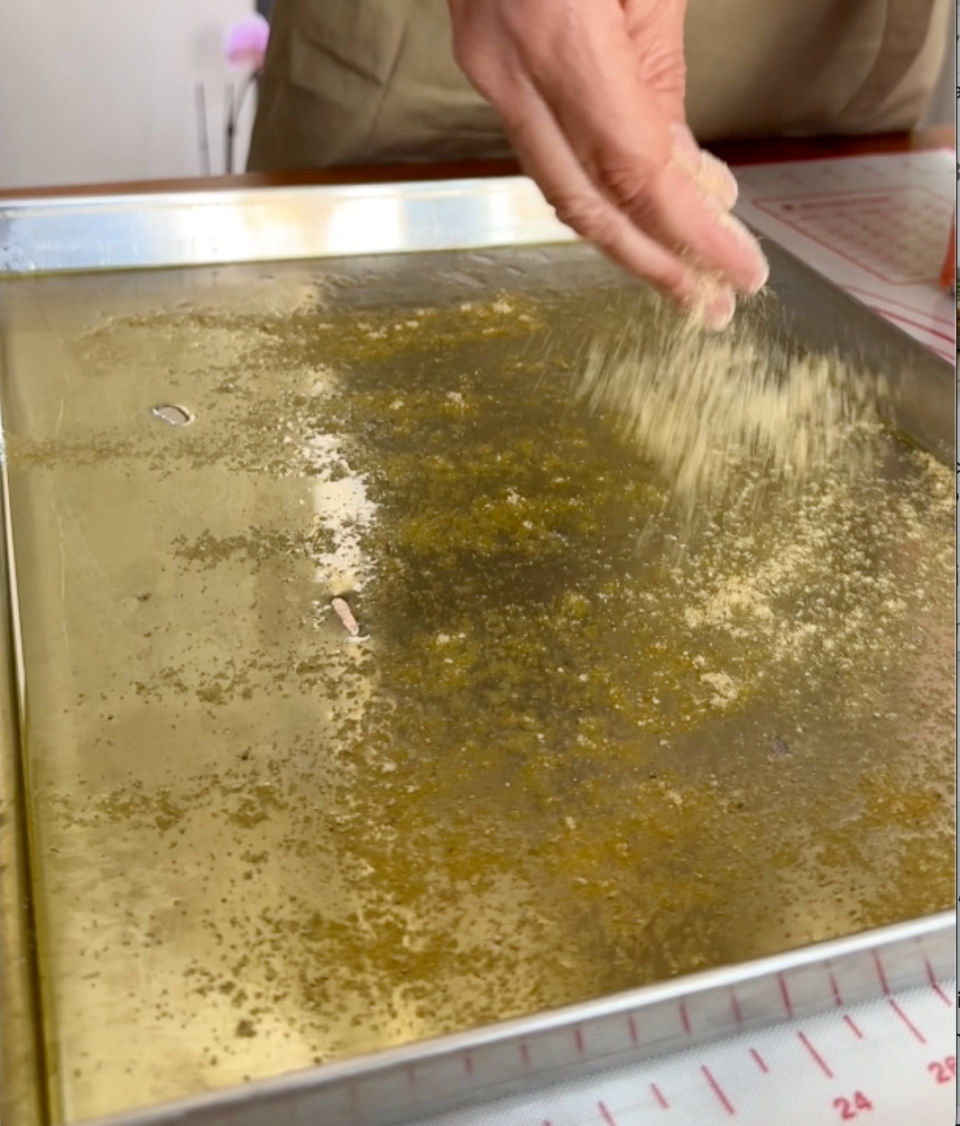 Spargere la farina di mais nella teglia unta