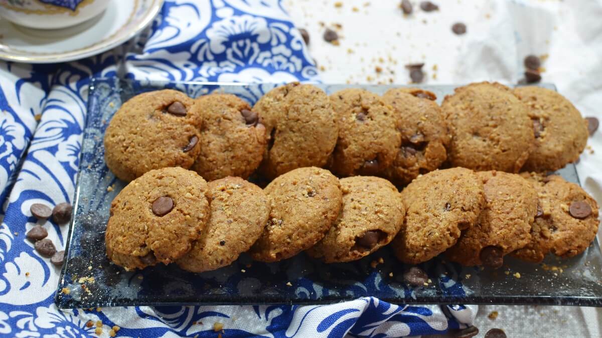 Biscotti integrali senza burro Ricetta Semplice su vassoio vetro con gocce e nocciole visibili