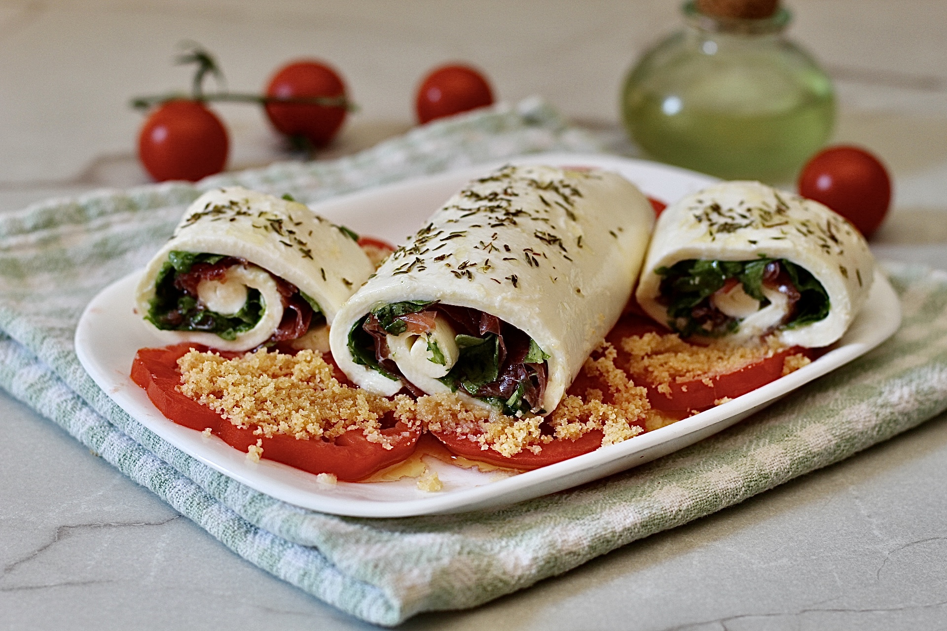Rotolo di mozzarella su carpaccio di pomodori, fresco e pronto in 5 minuti.