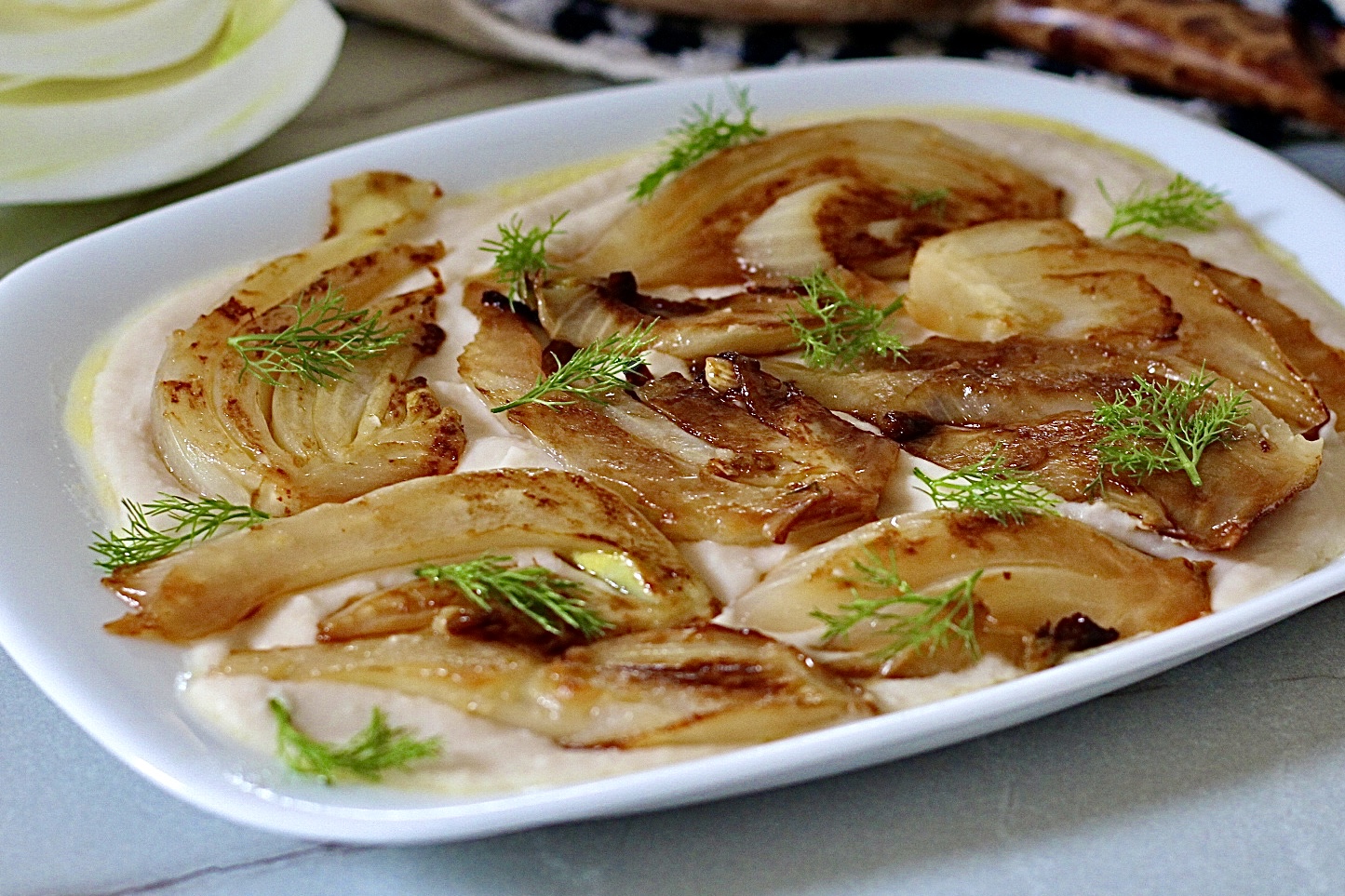 Finocchi salatati in padella su letto di crema di fagioli cannellini
