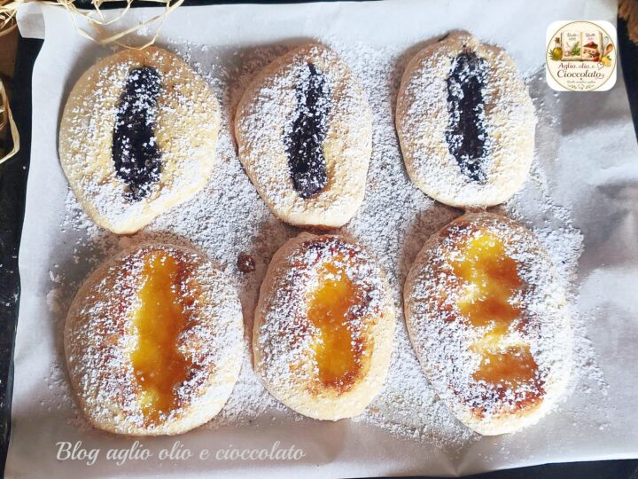 Biscotti morbidi senza burro e senza olio farciti con marmellata e crema al cioccolato, spolverati con zucchero a velo.