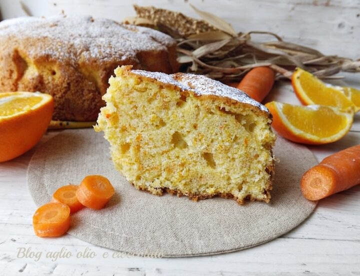 Fetta in primo piano di torta di carote e arancia soffice spolverata di zucchero a velo, con carote fresche