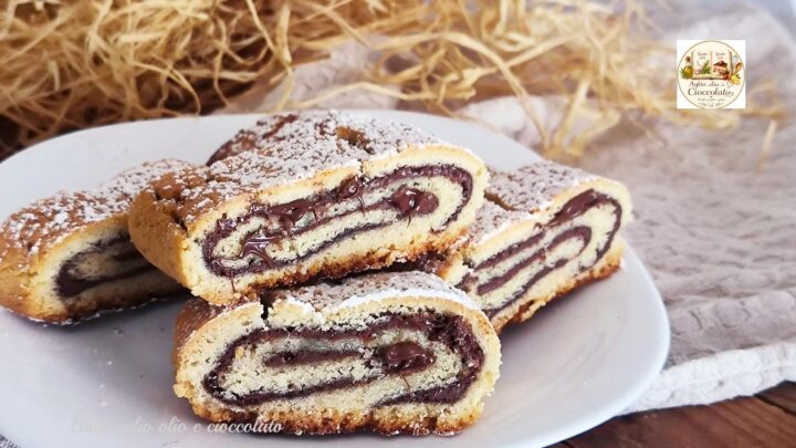 Biscotti arrotolati alla Nutella con frolla alla vaniglia, ripieno cremoso e zucchero a velo.
