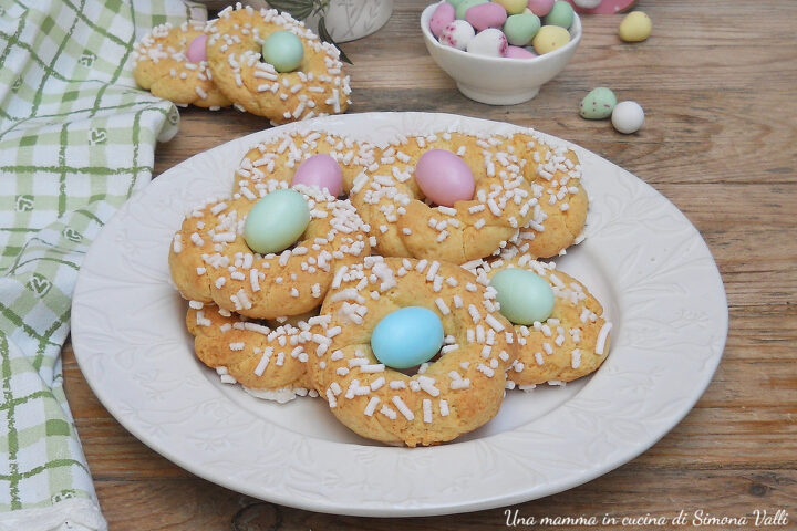 Le ciambelline di Pasqua sono deliziosi biscotti morbidi intrecciati che contengono all'interno un ovetto di cioccolato confettato.