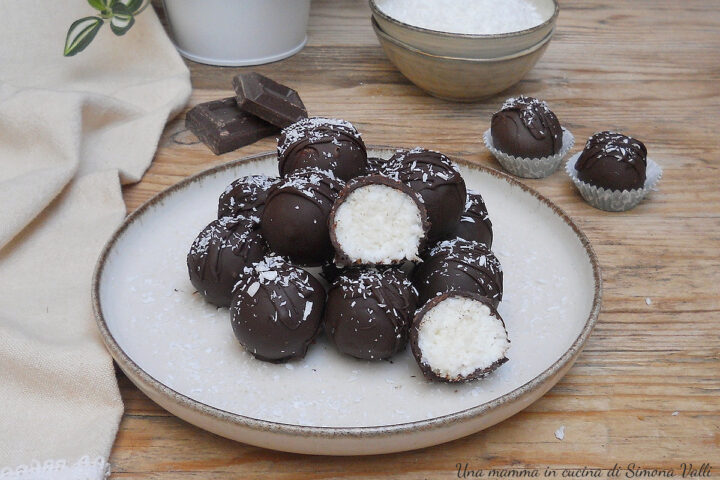Tartufini al cocco ricoperti di cioccolato tipo Bounty, dolcetto veloce e senza cottura con un cuore morbido e un guscio croccante.