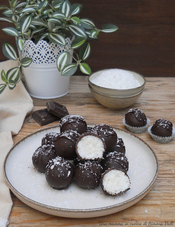 Tartufini al cocco ricoperti di cioccolato tipo Bounty, dolcetto veloce e senza cottura con un cuore morbido e un guscio croccante.