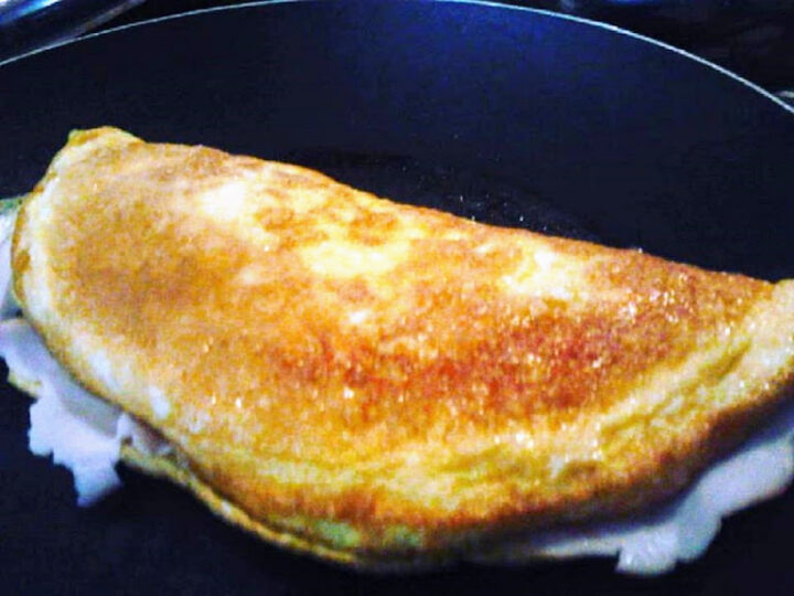 Omelette con prosciutto cotto e formaggio fuso in padella