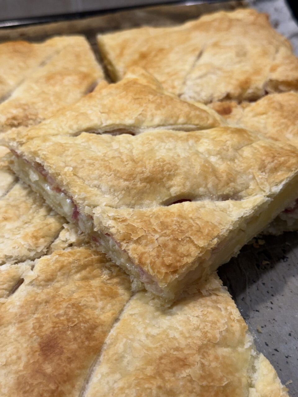 Torta salata di sfoglia con patate, prosciutto cotto alle erbe e provola