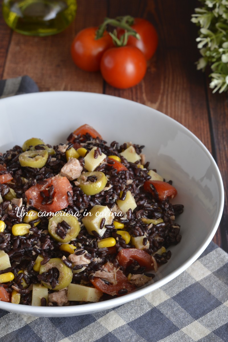 Insalata di riso nero venere con tonno e formaggio - Una cameriera in ...